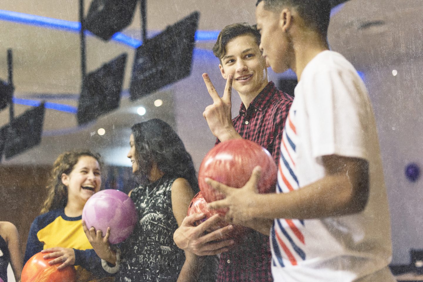 Group of young people laughing and bowling together