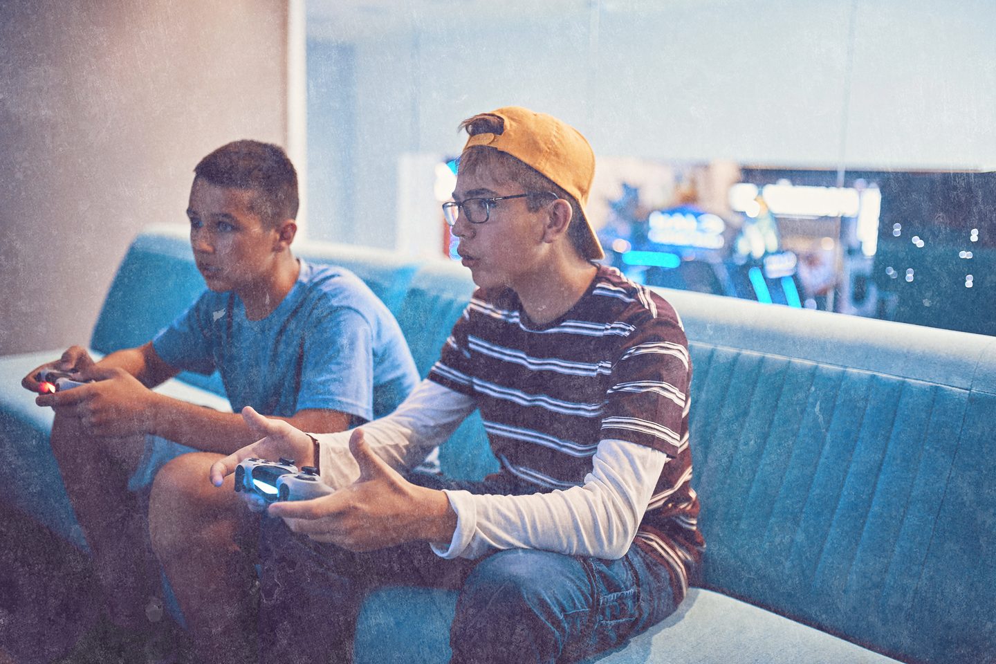 Young people playing video games together on a sofa