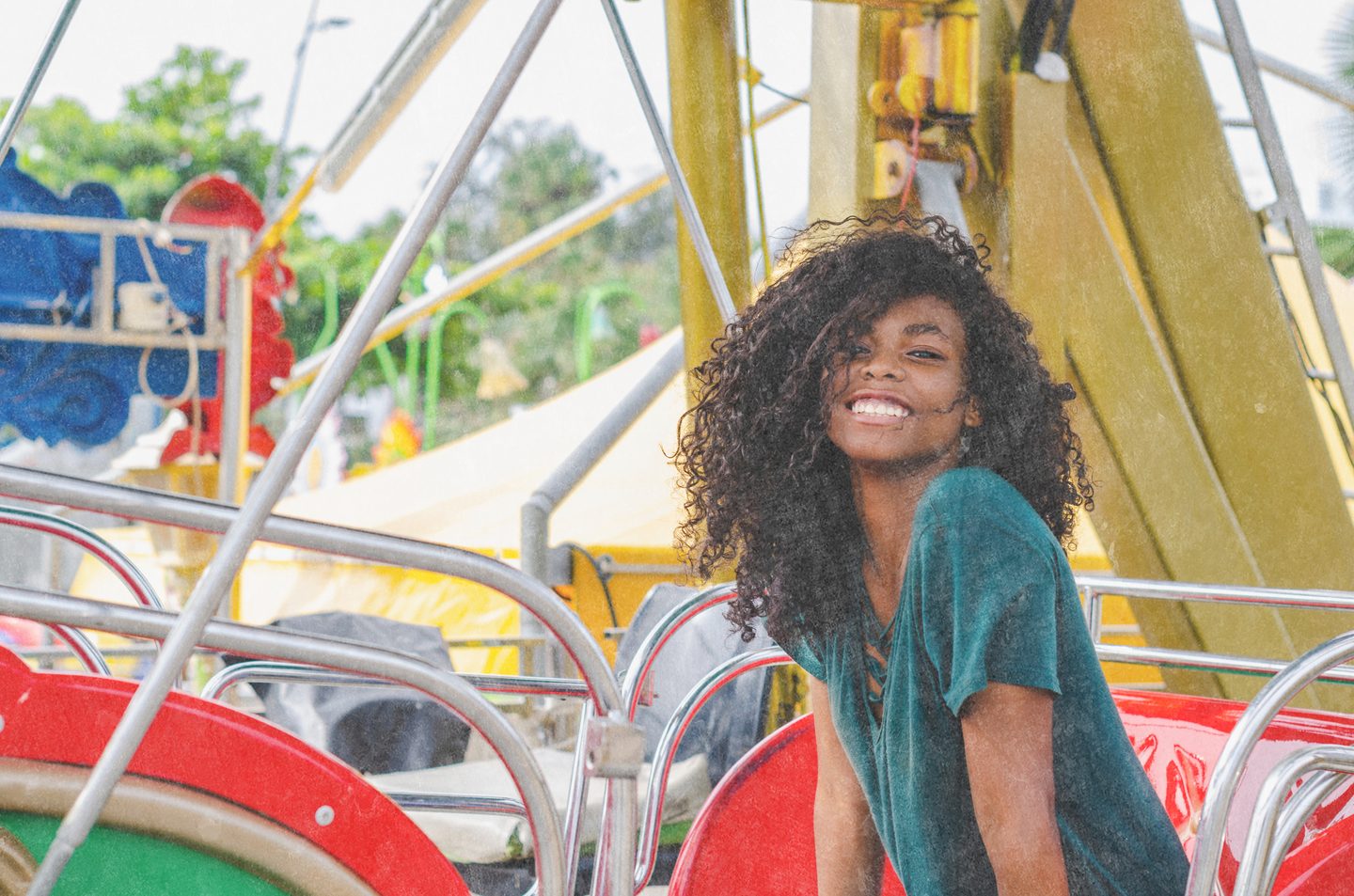 Young person smiling joyfully on a fairground ride