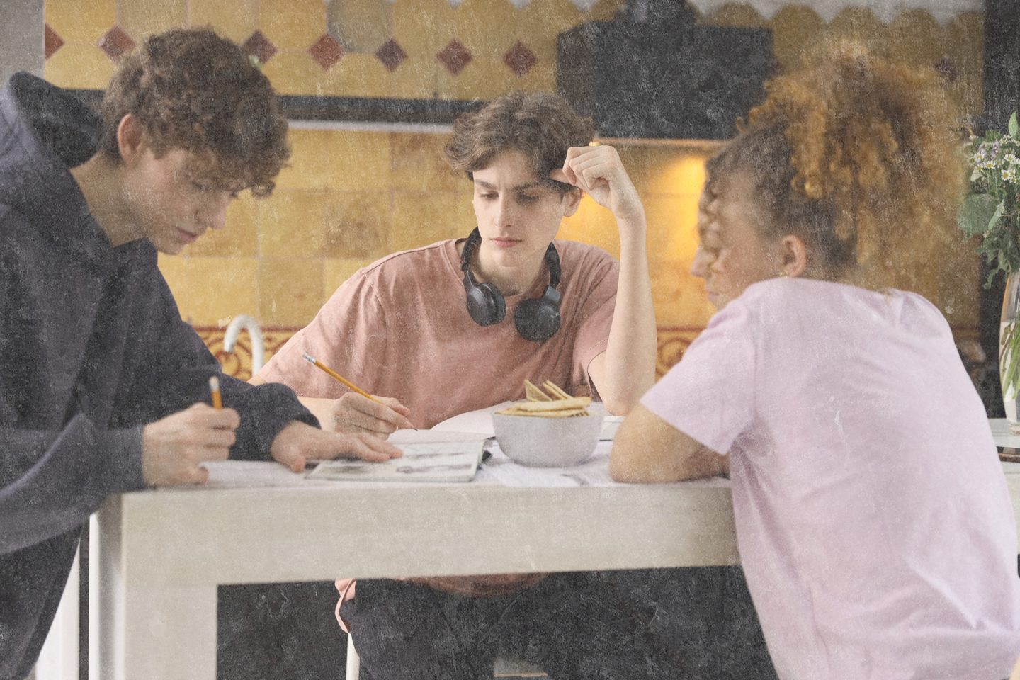 Young people studying together at a table in a supported living home